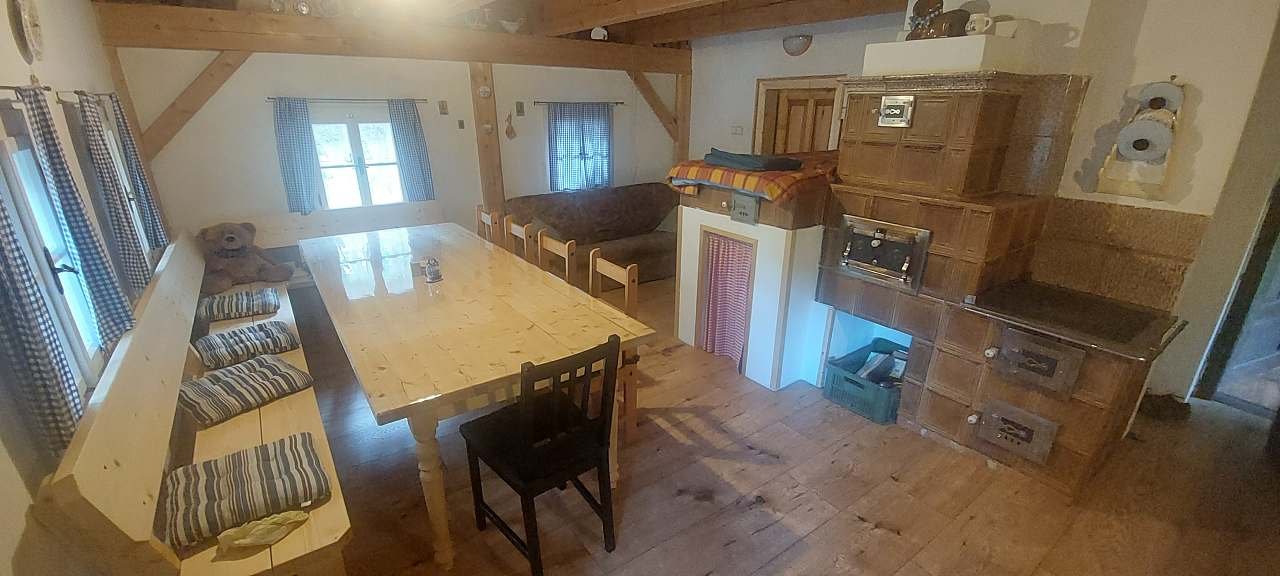Jídelna s pohledem na kachlová kamna a gauč