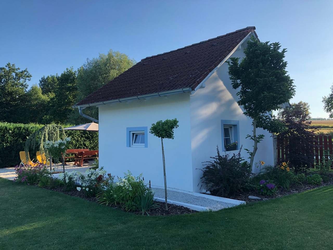 Kolem chatky jsou okrasné záhony