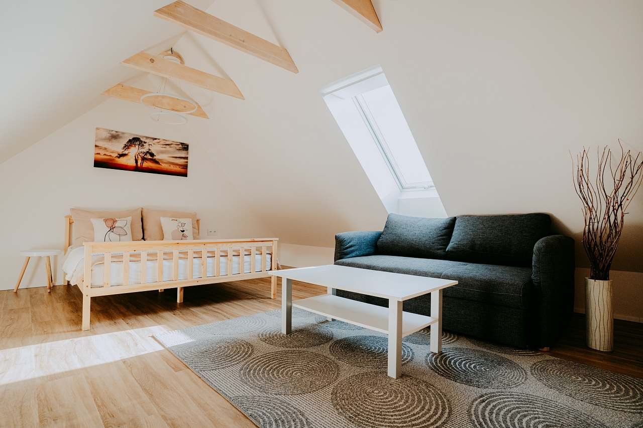 Podkrovní ložnice s manželskou postelí a rozkládací pohovkou