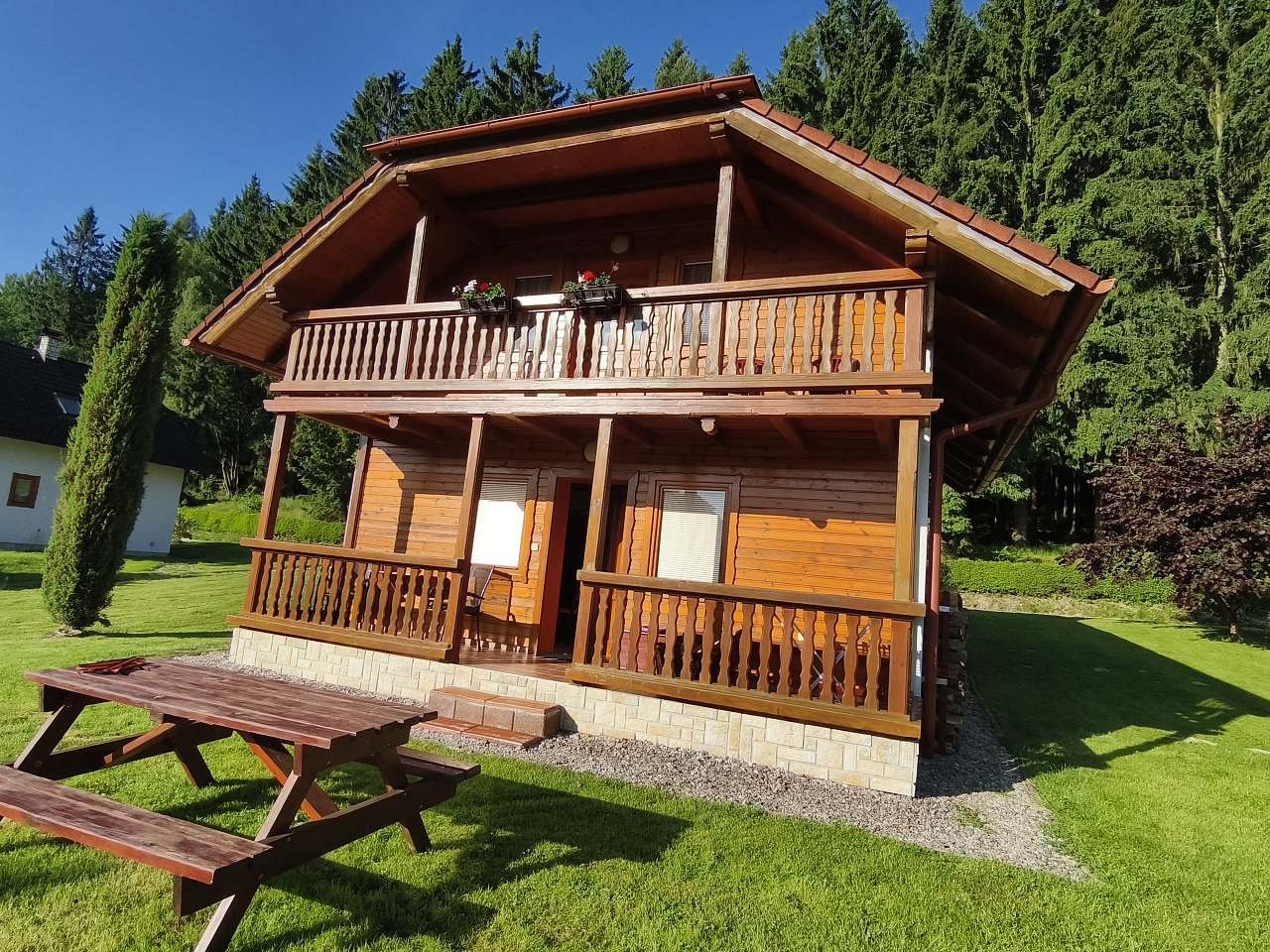 Pohled na chatu, okolí a les.