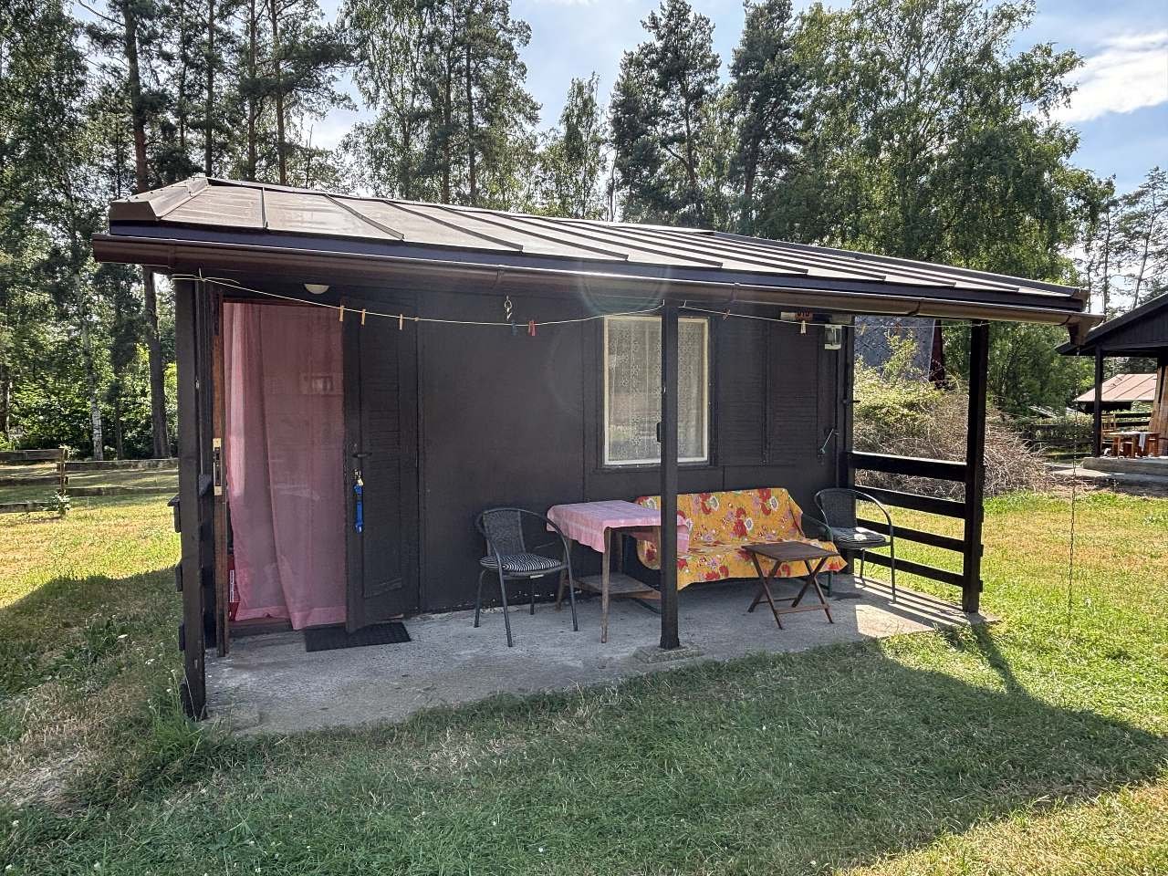 Pohled na přední část chaty a kryté venkovní posezení