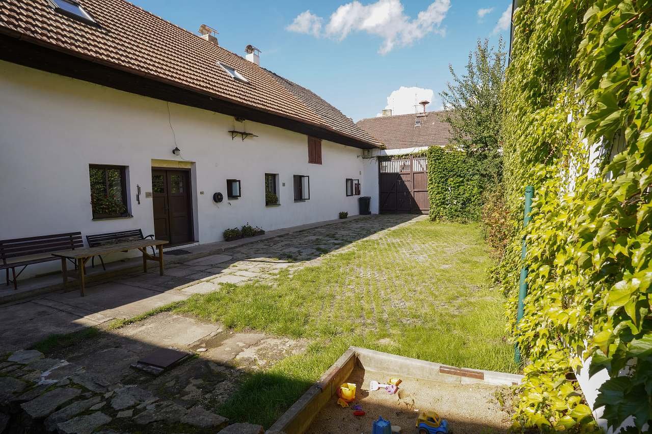 Prostorný uzavřený dvůr chalupy s pískovištěm pro děti