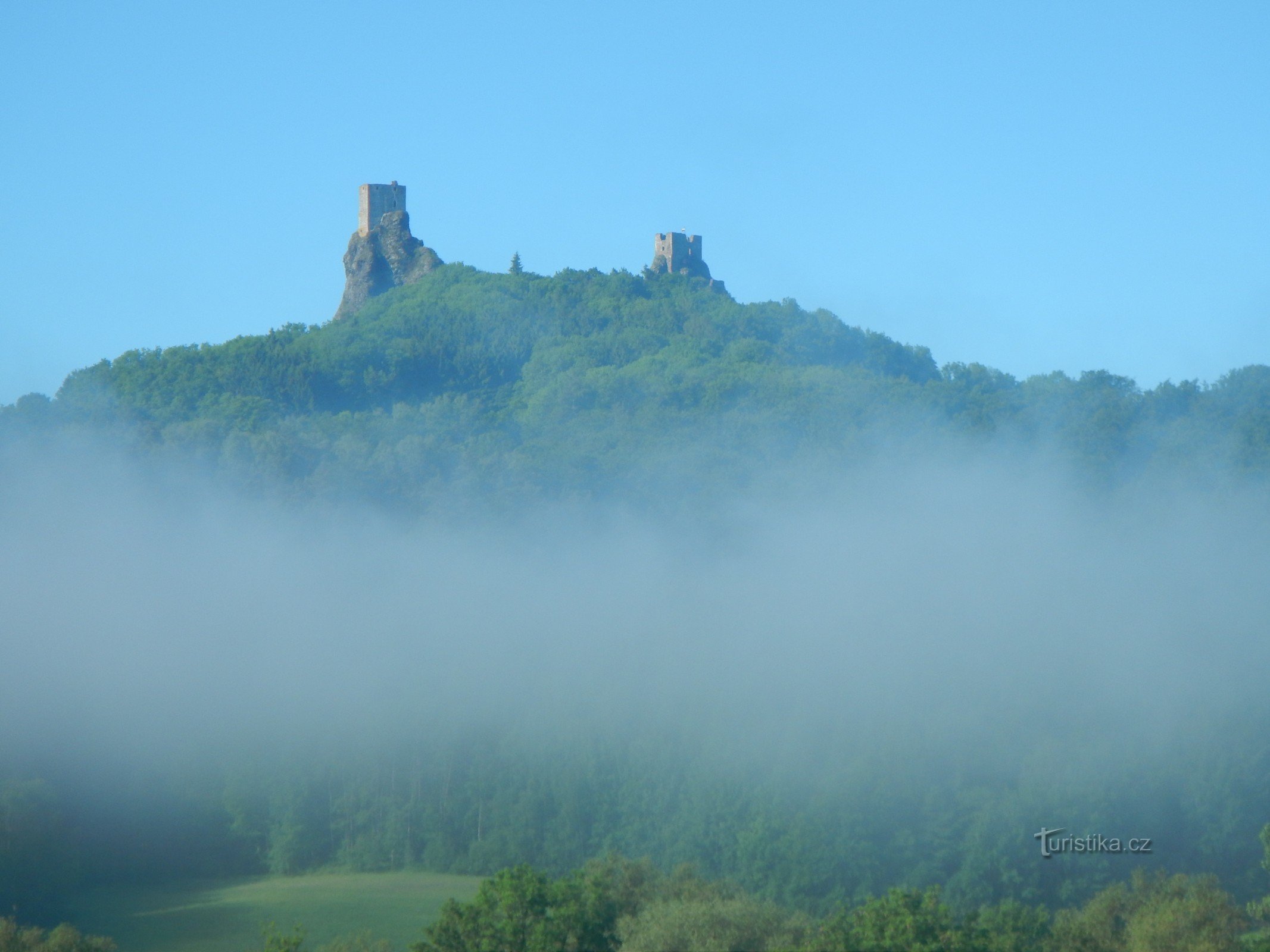 Trosky se probouzejí z mlžného oparu.