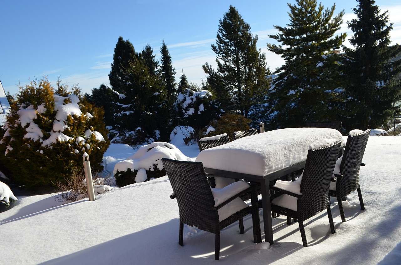 výhled z domu do zasněžené zahrady