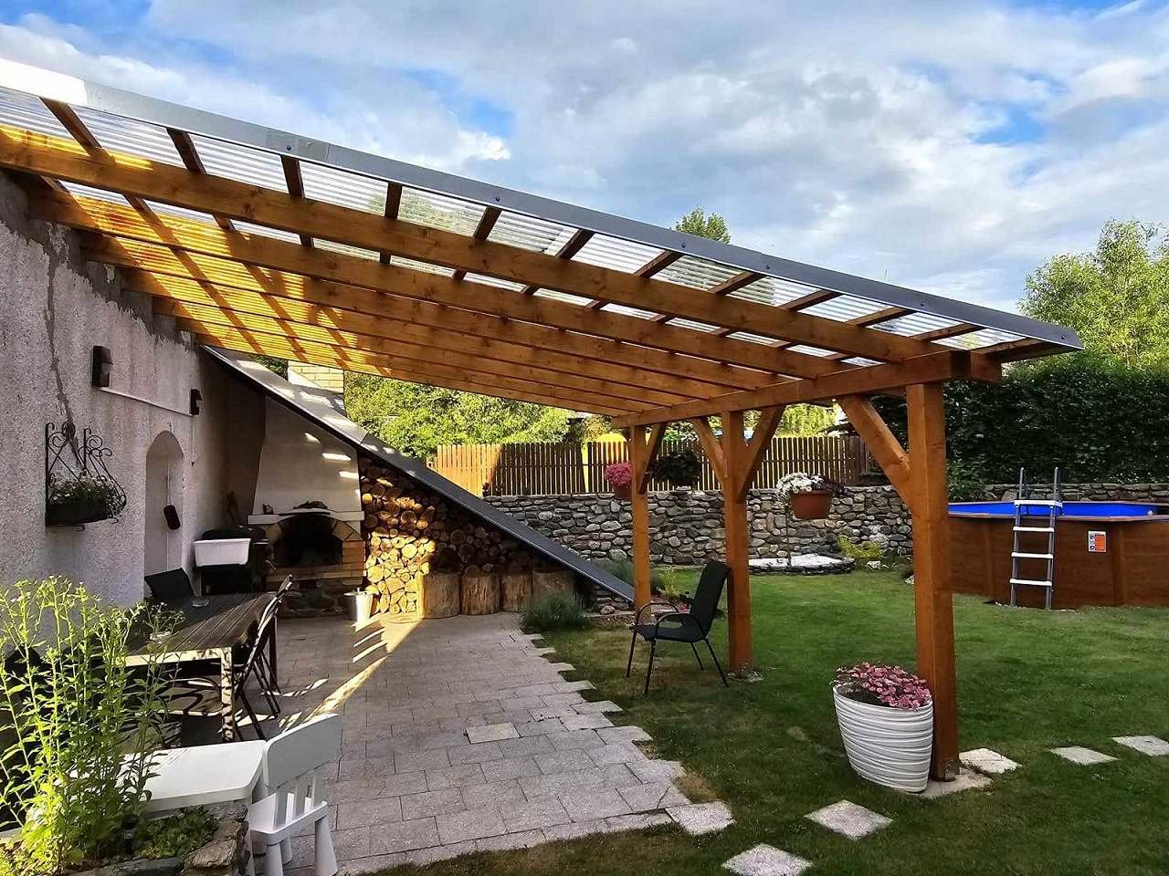 Zastřešená pergola s grilem s posezením, grilem a krbem.